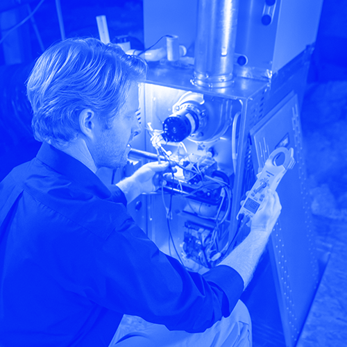 Technician working on furnace in home attic