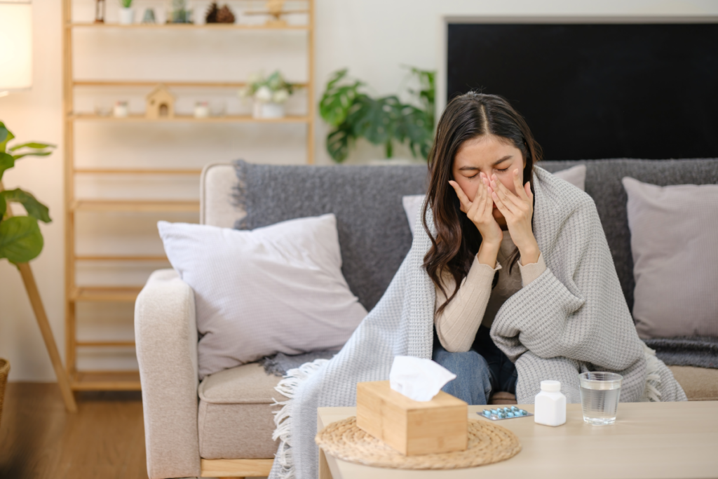 Image of woman sneezing in her home due to poor indoor air quality